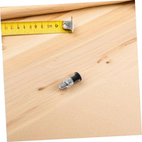 Heavy Duty Stainless Steel Reset Spring Indexing Plunger With Knockout Self Locking Grip on wooden surface next to measuring tape.
