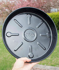 Hand holding 28cm base of 10 Inch Heavy Duty Plant Dolly With Wheels, 160 Lbs Capacity Metal Rolling Plant Stand, black round planter caddy