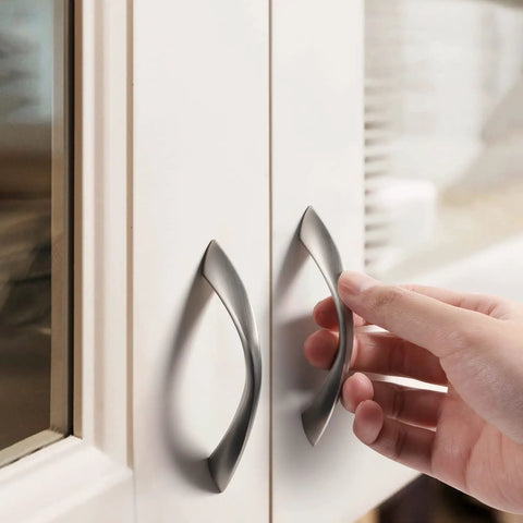 Brushed Nickel Cabinet Pulls 3 Inch Arch Twisted Silver Handles For Drawers And Cabinets Kitchen Cupboard Dresser Bathroom Zinc Alloy Heavy Duty Hardware being installed on white cabinet doors.