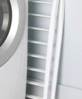 Freestanding Indoor Clothes Drying Rack Foldable Garment Hanger Compact Space Saving Design Lightweight White Finish leaning against the wall.