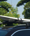 Car roof with soft roof rack pads with two 15 ft tie down straps for surfboard, durable waterproof 600D polyester padding, black pair installed