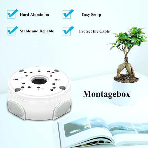 Heavy Duty Aluminum Waterproof Junction Box Mount Bracket For Bullet Security Cameras And Video Surveillance Systems Universal Fit IP66 Rated Weatherproof Cable Management Keeps Wiring Neat And Protected shown on a desk with a book and plant.