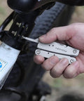 Using 14 In 1 Mini Multitool Lightweight With Folding Scissors And 9 Piece Bit Set on bike, compact multitool in hand