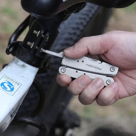 Using 14 In 1 Mini Multitool Lightweight With Folding Scissors And 9 Piece Bit Set on bike, compact multitool in hand