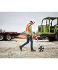 Person measuring ground distance with Built Different 12 Inch Digital Measuring Wheel Featuring Smooth Rubber Treader And Sturdy Spoked Frame Engineered For Precision Layouts And Heavy Duty Construction Projects Hooks Right Up With Milwaukee Gear.