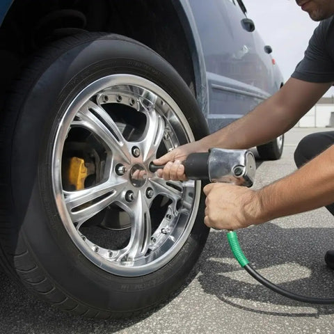 Person using Badass Heavy Duty Black Rubber Air Compressor Hose 3/8 Inch By 50 Feet 300 Psi on a car tire.