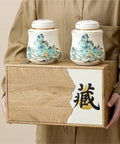 Vintage Airtight Ceramic Double Tea Canisters For Loose Leaf Coffee Beans And Spices on a wooden box, held by a person.