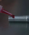 Applying Red High Temp Thread Locker For Engine Bolts 0.375 To 1 Inch Up To 450 Fahrenheit on metal bolt surface