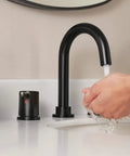 Person washing hands under Precept Widespread Matte Black Bathroom Faucet For 3-Hole 6-16 In. Install With ADA Push Pop-Up Drain