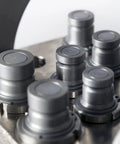 Gray metal 3/8-inch flat-face hydraulic quick-connect couplers with dust caps mounted on a manifold