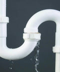 Water leak from a white PVC pipe under a sink, suitable for Water Activated Quick Fix Tape For Easy DIY Repairs Seal Leaks Cracks And Tears On Pipes Tools And More With A Simple Wrap And Quick Durable Hold That Sticks For A Strong Leak Free Seal.
