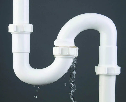Water leak from a white PVC pipe under a sink, suitable for Water Activated Quick Fix Tape For Easy DIY Repairs Seal Leaks Cracks And Tears On Pipes Tools And More With A Simple Wrap And Quick Durable Hold That Sticks For A Strong Leak Free Seal.