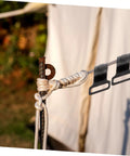 10 Pack Plastic Tent Pole Hooks For Glamping And Camping Gear Hanger attached to a rope outdoors next to a tent.