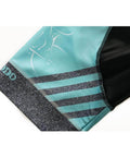 Close-up of teal and black athletic shorts with stripe design and logo on the hem
