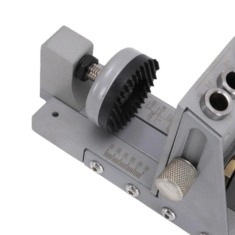 Close-up of adjustable pocket hole jig kit with steel bushing, measuring scale, for woodworking cabinet projects.