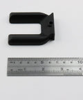 Black plastic wheel stopper from 4Pcs Wheel Stopper Set No Slip Caster Cups For 2 Inch Wheels next to a ruler for scale.