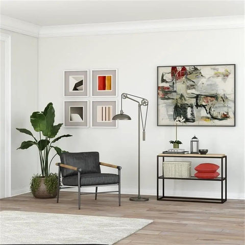 Spoke Wheel Pulley Floor Lamp With Metal Shade In Aged Steel Finish for industrial living room decor, next to artwork and armchair.