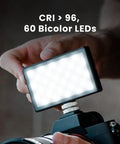 Person holding Pocket Sized Pro Grade Bicolor Panel Mini LED Light For DSLRs With Adjustable Panel And LCD Display over camera