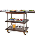 Serving cart with dark wood shelves, silver poles, and gold caster wheels. Topped with plates of food and drinks.