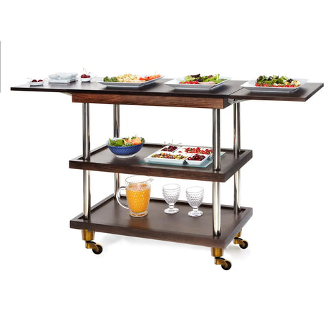 Serving cart with dark wood shelves, silver poles, and gold caster wheels. Topped with plates of food and drinks.