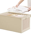 No Stress Foldable Storage Cubes With Heavy Duty Dual Handles For Thick Blankets Linens And Winter Jackets Fast To Flatten And Stack Away Every Single Day, beige storage cube with laundry being added.