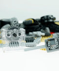 Close-up of Gear Builder Bulk Kit for Brick Creations, featuring clear gearbox, gears, axles, and universal joints on a white background.