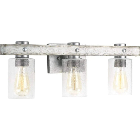 Gulliver Collection Three Light Clear Seeded Glass Coastal Bath Vanity Light In Galvanized Finish with whitewashed wood grain band.