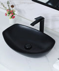 Black ceramic vessel sink on countertop with faucet and flowers on the side, different from White Ceramic Vessel Sink 19 By 14.5 Inch With Pop Up Drain Above Counter Bathroom Sink Modern Vessel Bowl For Vanity Durable Glazed Ceramic Finish Countertop Sink For Stylish Homes