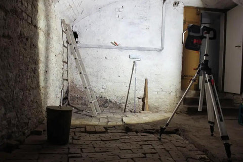 4,000 Lumen 18V Bluetooth LED Floodlight With Remote Control lighting a workshop with brick floor and tools, durable metal body