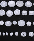 Grab This Awesome DIY Robot Gears And Pulley Belt Kit With 64 Kinds Of Wearable Plastic Parts Perfect For Tech Models, Car Robots, And Cool Motor Projects You Can Build Your Own Stuff With Today. White plastic gears set on black background