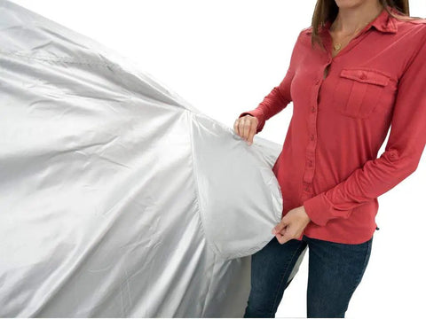 Woman holding Heavy Duty All Weather Car Cover Gonna Shield Your Tesla Model S Like Armor, showcasing breathable silver material.