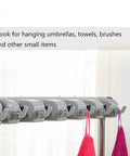Close-up of the 26 Inch Stainless Steel Broom And Mop Holder Rack With Built In Water Basin hooks holding towels