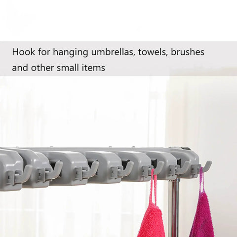 Close-up of the 26 Inch Stainless Steel Broom And Mop Holder Rack With Built In Water Basin hooks holding towels