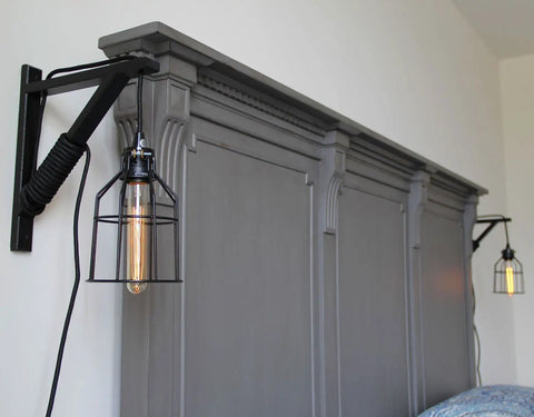 Black Wooden Triangle Wall Mount Brackets for Sconce Lighting above gray paneling with pendant lights