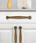 10 Pack 4 Inch Center To Center Antique Brass Cabinet Pulls for dressers, bathrooms, and kitchen cabinets installed on white cabinet doors.