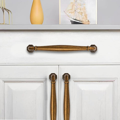 10 Pack 4 Inch Center To Center Antique Brass Cabinet Pulls for dressers, bathrooms, and kitchen cabinets installed on white cabinet doors.