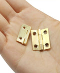 Compact Brass Mini Hinges One Inch Ten Pack With Pre Drilled Screws Ideal For Jewelry Boxes Woodworking Crafts And Tiny Gift Cases displayed in hand.