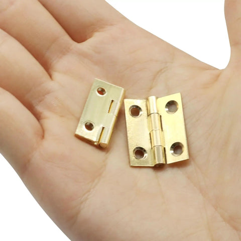 Compact Brass Mini Hinges One Inch Ten Pack With Pre Drilled Screws Ideal For Jewelry Boxes Woodworking Crafts And Tiny Gift Cases displayed in hand.