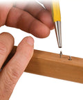 Heavy Duty Blind Nail Kit Packed With Eighty Invisible Fasteners Built For Slick Trim Work And Tight Woodworking Joints That Deliver A Flawless Clean Finish On Every Weekend Warrior Build, hand holding setting tool on wood.