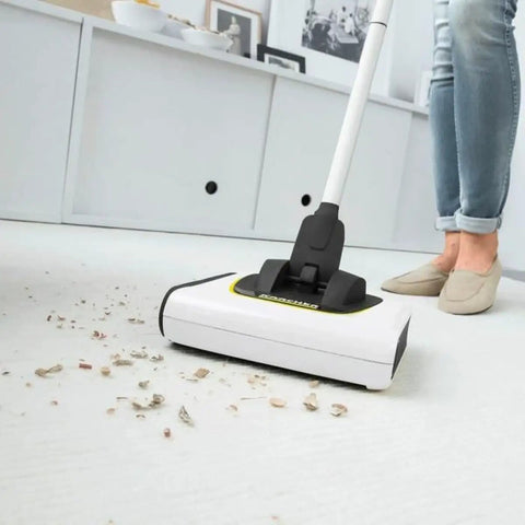 Cordless Electric Floor Sweeper Broom With Whisper Quiet Rollers For Hardwood Vinyl Tile And Rugs Lightweight Automatic Sweeper Machine For Pet Fur Hair Dust And Household Mess White cleaning debris on a light surface.