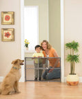Adjustable Baby Gate For Doorways With Pressure Mount No Drill Setup Easy Tool Free Install Kid Friendly Pet Safe Gate Vintage Wood Gray Perfect For Toddlers And Pets in a home setting with a child and dog.