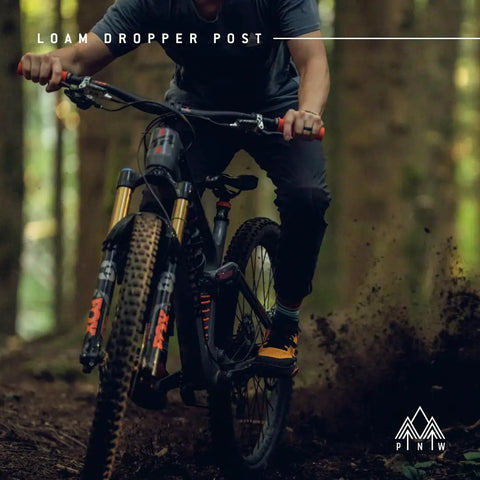 Mountain biker using Loam Dropper Post Gen 2 Black Internal Routing MTB Seatpost With 25mm Adjustable Travel on forest trail