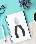Metal Single Hole Puncher With Ergonomic Handles And Built In Guide on notebook, surrounded by pen and coffee.
