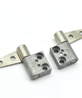 Two ST-7A-50SA/SB-33 damping hinges with mounting tabs; silver metal, front view