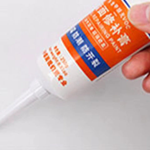 Hand holding fast drying wall repair paste crack filler kit for drywall holes patches in home living room kitchen basement garage office