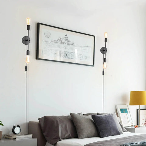 Lit Two-Light Black Bathroom Vanity Light Fixtures Set Of Two beside bed with artwork, modern industrial wall sconces with cords.