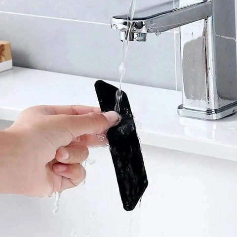 Person washing a strip from Non Slip Rug Tape Gripper Set 8 Pieces Reusable Double Sided Carpet Tape For Area Rugs On Hardwood Floors Strong Hold Adhesive Strips Perfect For Keeping Rugs In Place under running water