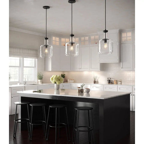 Latrobe Collection 1-Light Clear Glass Coastal Pendant Light in Matte Black above kitchen island with bottle-shaped shades