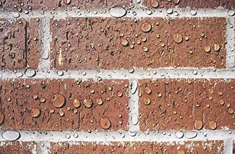 The Real Deal Deep Penetrating Siloxane Masonry Sealer For Brick Concrete And Stucco Hydrophobic Waterproof Barrier Coating With Extended All Weather Defense visible on wet brick wall with water beads.