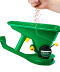 Cordless Handheld Seed And Fertilizer Spreader With Adjustable Feed Rate being filled for even coverage use in gardens